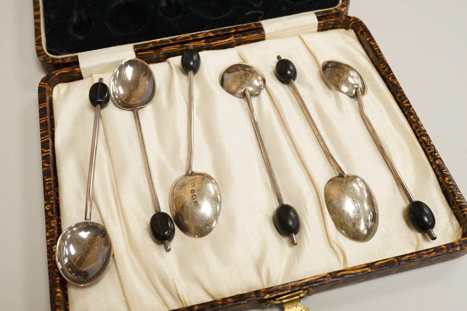 A cased pair of Victorian silver circular salts, by Edward Hutton, London, 1886, lacking spoons, together with a cased set of six silver bean end coffee spoons, a cased silver spoon, a small silver 'Dunlop Golf Ball Hole